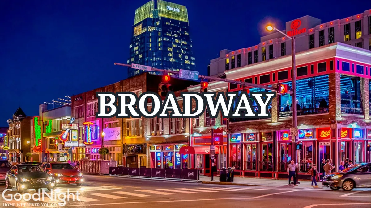 A dynamic night scene featuring neon signs, crowded streets, and a modern skyscraper backdrop. The area buzzes with activity as locals and visitors enjoy dining, live music, and nightlife. The neon glow and packed sidewalks convey a sense of excitement and entertainment.