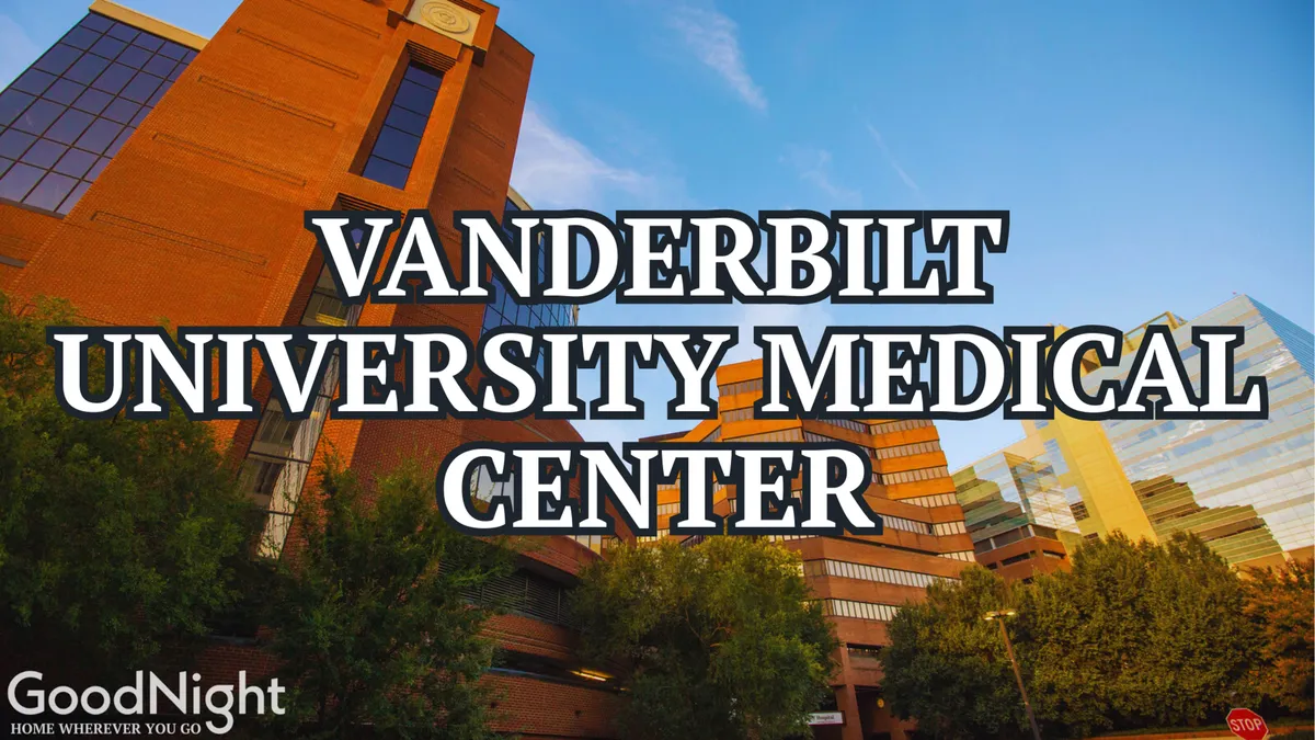 The exterior of Vanderbilt University Medical Center, framed by lush greenery and Nashville’s skyline in the background. The modern medical complex is prominent, signaling both its stature and convenience for visitors needing quick access to healthcare or research facilities.